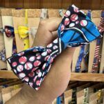 Colorido lazo de tela con estampado de puntos y dibujos, ideal para accesorios y decoración.