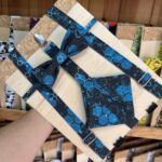 Corbata y cinturón con diseño futurista y detalles tecnológicos en tonos azules y negros.