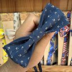 1. Accesorio de tela con estampado de pequeñas flores blancas en fondo azul marino.