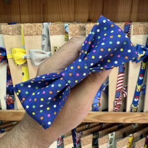 Elojo de la diadema estilo moño con estampado de puntos en colores vibrantes sobre fondo azul.