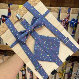 Colorido conjunto de corbata y cinturón con diseño de bloques de colores en fondo azul.
