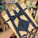 Alto texto: Correa de bolsos y accesorios con estampado floral en tonos oscuros.