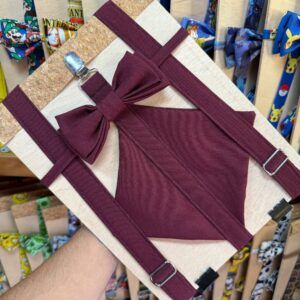 Lazo para cabello burdeos con fondo de madera y accesorios de bolsas de personajes de videojuegos.