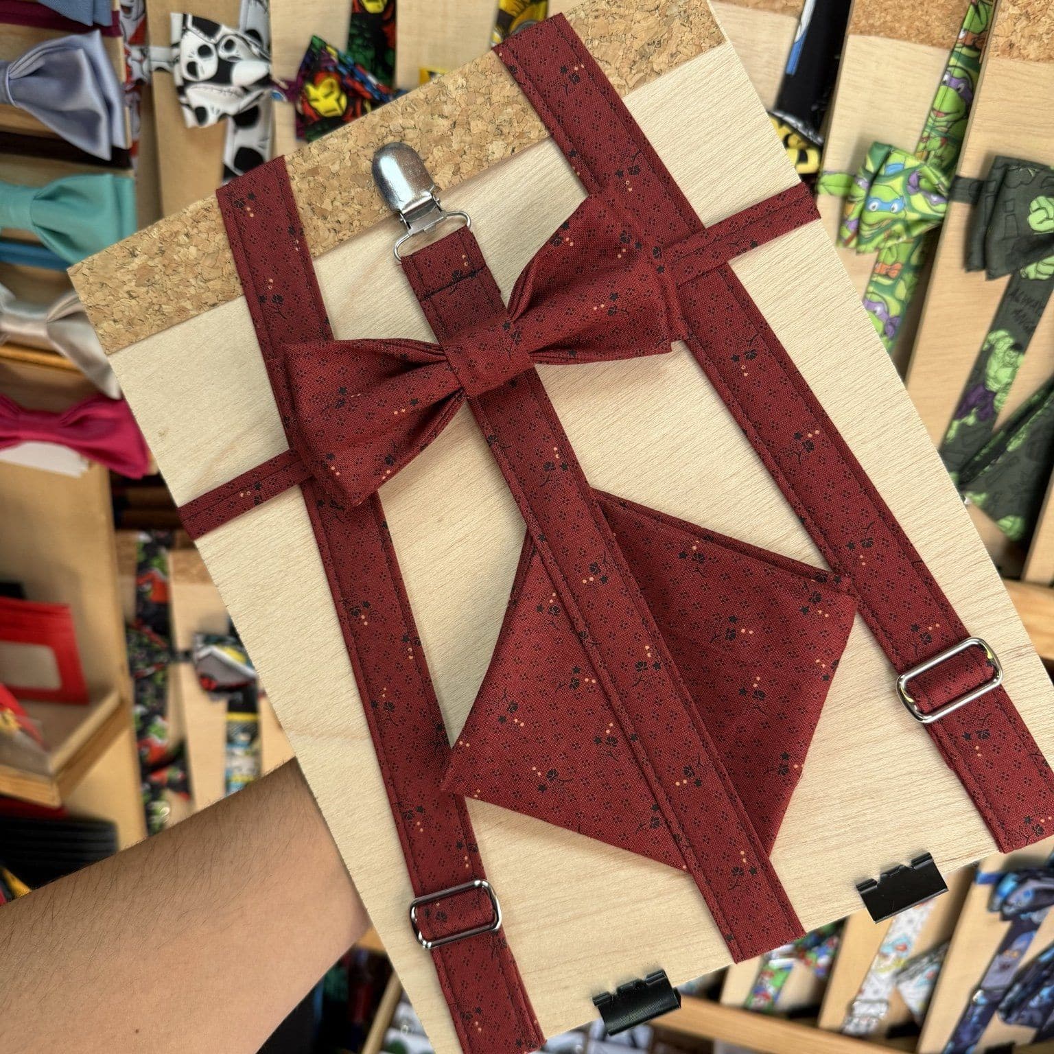 Cinta de tela con lazo y sujetador en tablero de madera, ideal para decoración y manualidades creativas.