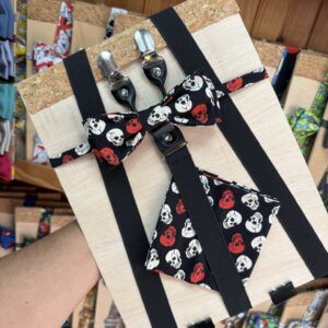 1. Llavero con estampado de calaveras en color negro, rojo y blanco, en caja de madera con cinta negra.