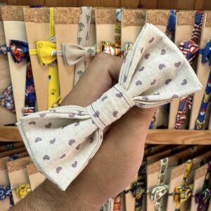 1. Listón de tela con lazo de puntos en tonos beige y morado, ideal para accesorios de moda y manualidades.