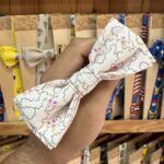 1. Lazo de tela color blanco con estampados y puntada decorativa.