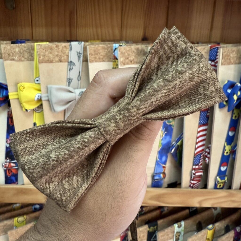 Lazo de tela con estampado en tonos dorados y marrones, ideal para accesorios y prendas de vestir.