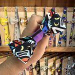 Colorido lazo de tela con diseño de personajes y patrones llamativos, ideal para accesorios de moda y bisutería.