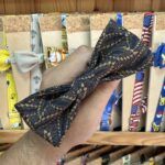 1. Lazo de tela negra con diseño en dorado, accesorio para cabello o moda.