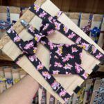 Diverso conjunto de accesorios con motivo de ponis en colores rosa y amarillo en fondo negro.