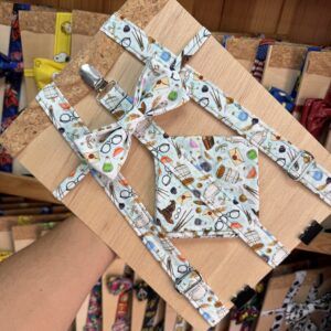 Arnés y lazo de tela con estampado de instrumentos musicales, en tienda de artesanías y accesorios creativos.