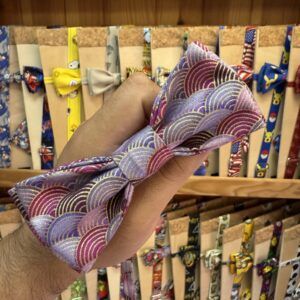 Foulard con estampado geométrico en tonos púrpura, dorado y rosa para accesorios elegantes.