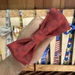 1. Laço de cabelo vermelho com padrão de círculos, feito de tecido leve e elegante.
