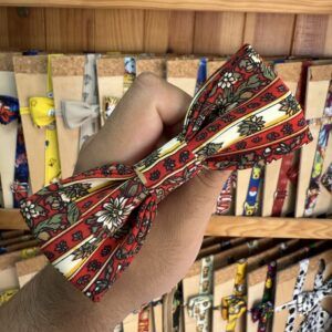 1. Lazo de diadema con diseño floral y rayas en tonos rojos, blancos y verdes.