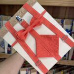 Corbata de lazo con suspensor en tela roja con puntos blancos, ideal para accesorios de moda femenina.