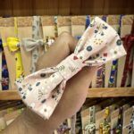 Cinta con lazo floral en tonos rosas y colores suaves, ideal para accesorios de moda y peinados femeninos.