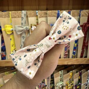 Cinta con lazo floral en tonos rosas y colores suaves, ideal para accesorios de moda y peinados femeninos.