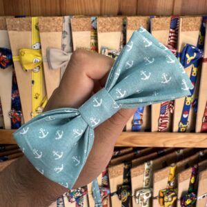 Pajarita azul con anclas blancas, estilo náutico, en tienda de accesorios de cabello y complementos.