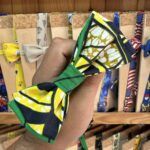 Cinta de bandana con diseño de mariposa en colores amarillo, negro y verde.