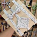 Correa de tela con lazo floral para mascotas, en exhibidor de tienda de accesorios para perros y gatos.
