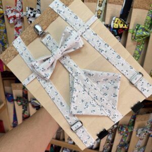 Correa de tela con lazo floral para mascotas, en exhibidor de tienda de accesorios para perros y gatos.