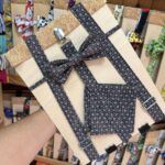 Lazo para cabello con estampado de florecitas en tonos oscuros, decorado en caja de madera para regalos.