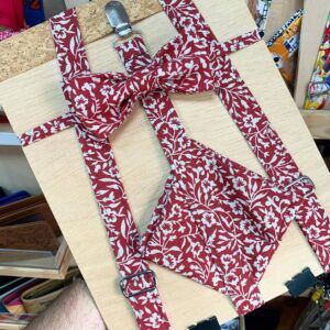 1. Correas de peto con estampado floral rojo y blanco para niña, en madera y accesorios metálicos.