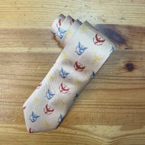 Corbata de seda con estampado náutico de anclas en colores rojo, azul y amarillo, ideal para eventos formales y ocasiones especiales.
