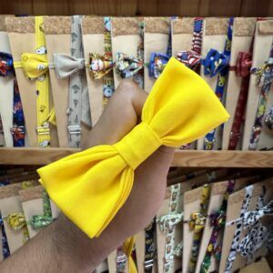 Tira para el pelo de tela amarilla con lazo grande y diseño liso, ideal para accesorios y peinados infantiles.