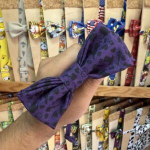 1. Lazo de tela estampado en color morado con manchas negras, para mascotas o accesorios.