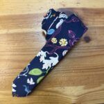 Banda de tela con estampado floral y animal en tonos oscuros, ideal para moda y complementos.