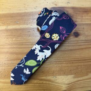Banda de tela con estampado floral y animal en tonos oscuros, ideal para moda y complementos.