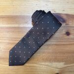 Corbata de seda negra con detalles de puntos blancos, elegante y moderna para ocasiones formales.