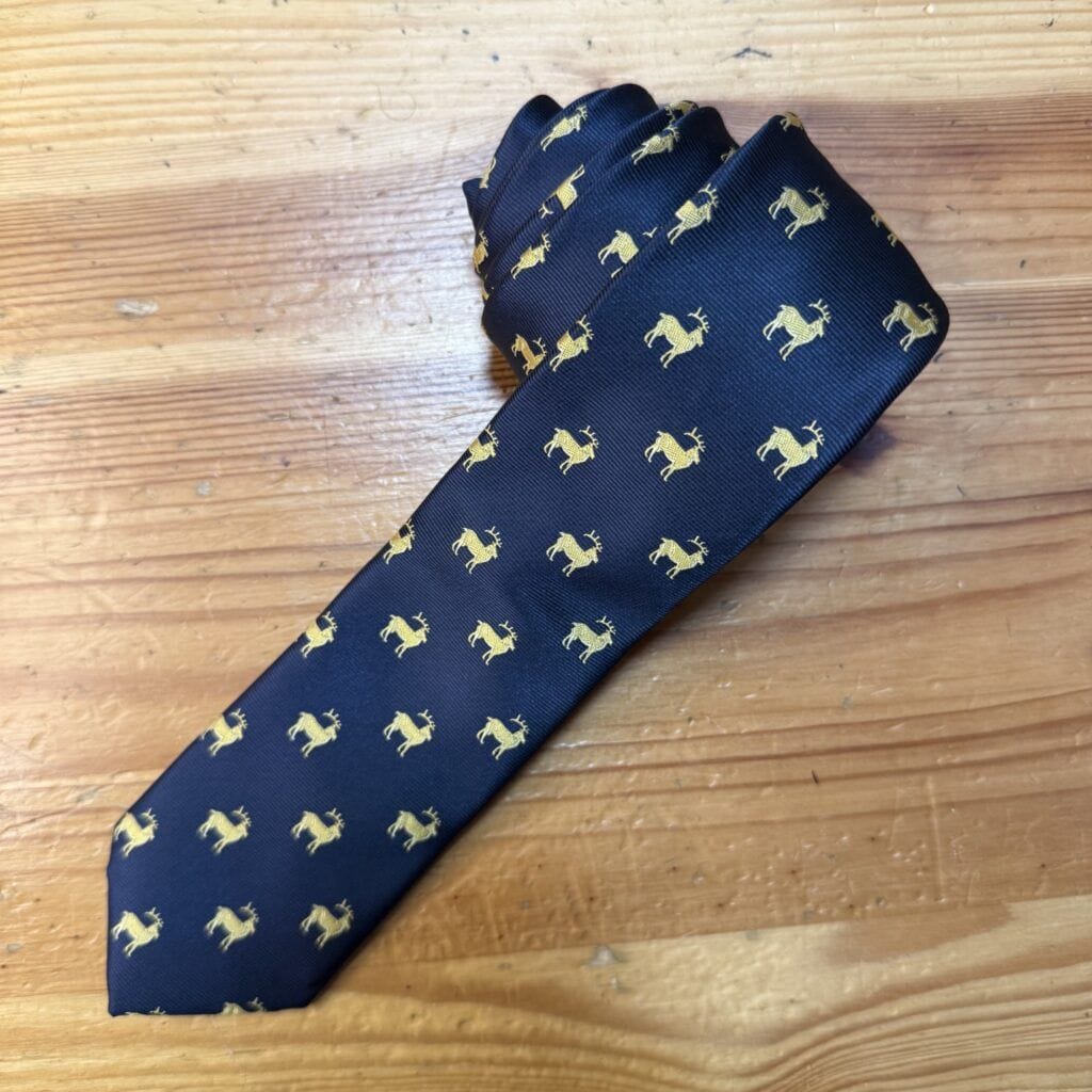 Corbata azul con estampado de ciervos en color dorado para hombre elegante.