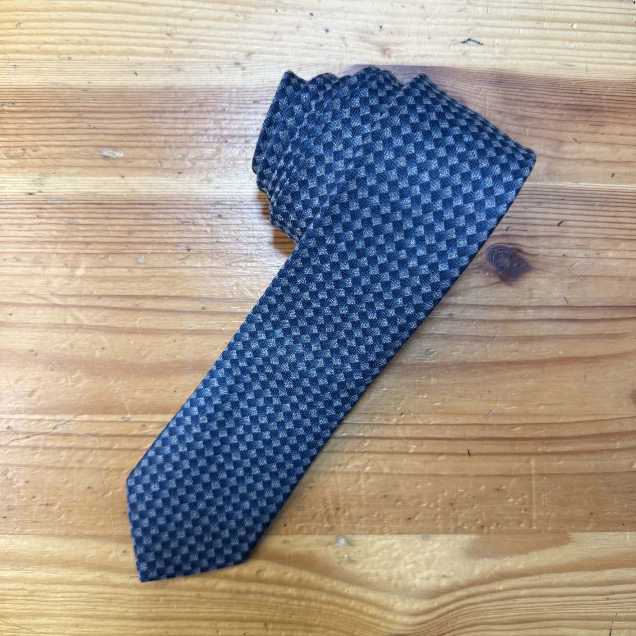 Corbata en tonos azules con patrón de cuadros, ideal para accesorios masculinos elegantes.