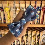 Colorido lazo de tela con personajes de dibujos animados, ideal para accesorios infantiles y mascotas.