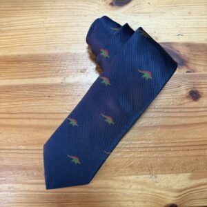 Corbata azul con diseño de dinosaurios verdes y rojos, elegante y original para ocasiones especiales.