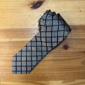 Corbata de estampado clásico en negro y blanco, diseño a cuadros para ocasiones formales.