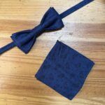 Tamaño de la pajarita y pañuelo de traje azul con estampado floral para eventos formales.