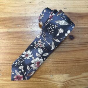Corbata de seda azul con florales blancas y rosadas, diseño elegante y moderno para niños y adultos.