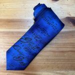Corbata azul con notas musicales y letra, diseño original para amantes de la música.
