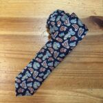 Tira de tela con estampado pañuelo en tonos azul, rojo y beige, diseñada para accesorios de moda y artesanía.