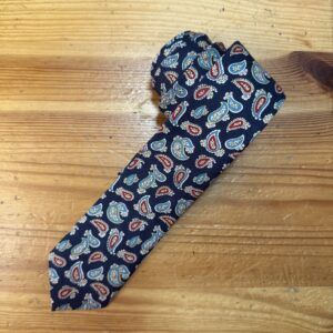 Tira de tela con estampado pañuelo en tonos azul, rojo y beige, diseñada para accesorios de moda y artesanía.