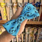 Sombrero de tela azul con estampado de balones de fútbol, ideal para fanáticos del deporte.