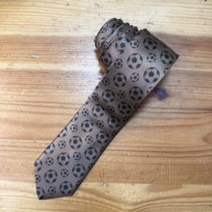 Corbata con diseño de balones de fútbol en tonos oscuros, ideal para eventos deportivos y casuales.