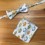 1. Corbata y pañuelo a juego con estampado de barcos de papel en color azul, amarillo y naranja.