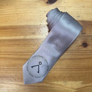 Corbata gris seda con logotipo de Carmenatis, accesorios para eventos y bodas elegantes.