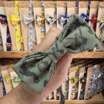 1. Lazo de tela con estampado de animales en tonos verdes y oscuros.
