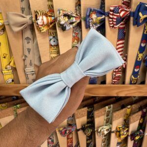 1. Lazo de tela azul claro con nudo en la mano de una persona, en tienda de accesorios.